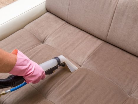 Parramatta cleaner extracting dirt off a brown sofa